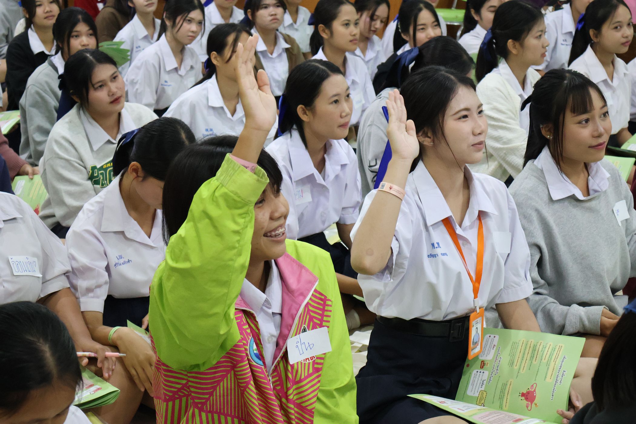 The students are raising their hand to answer the question.