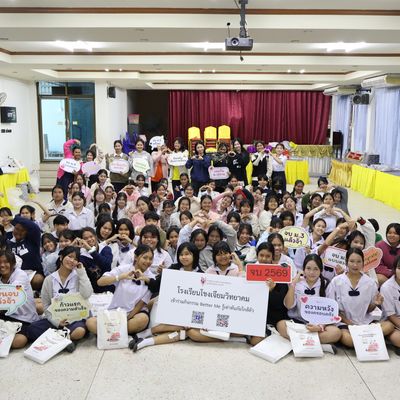 Large group of students and teacher are smiling at the camera