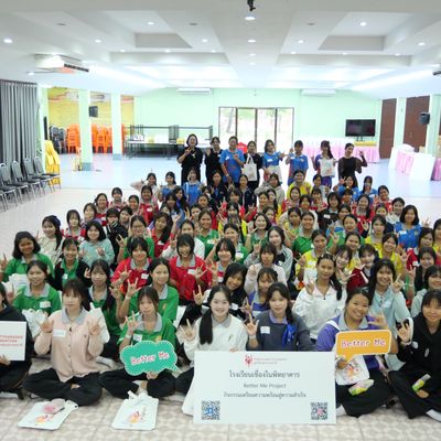 Students and teacher are smiling at the camera