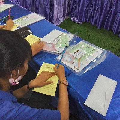 A student is writing on a reflection sheet.