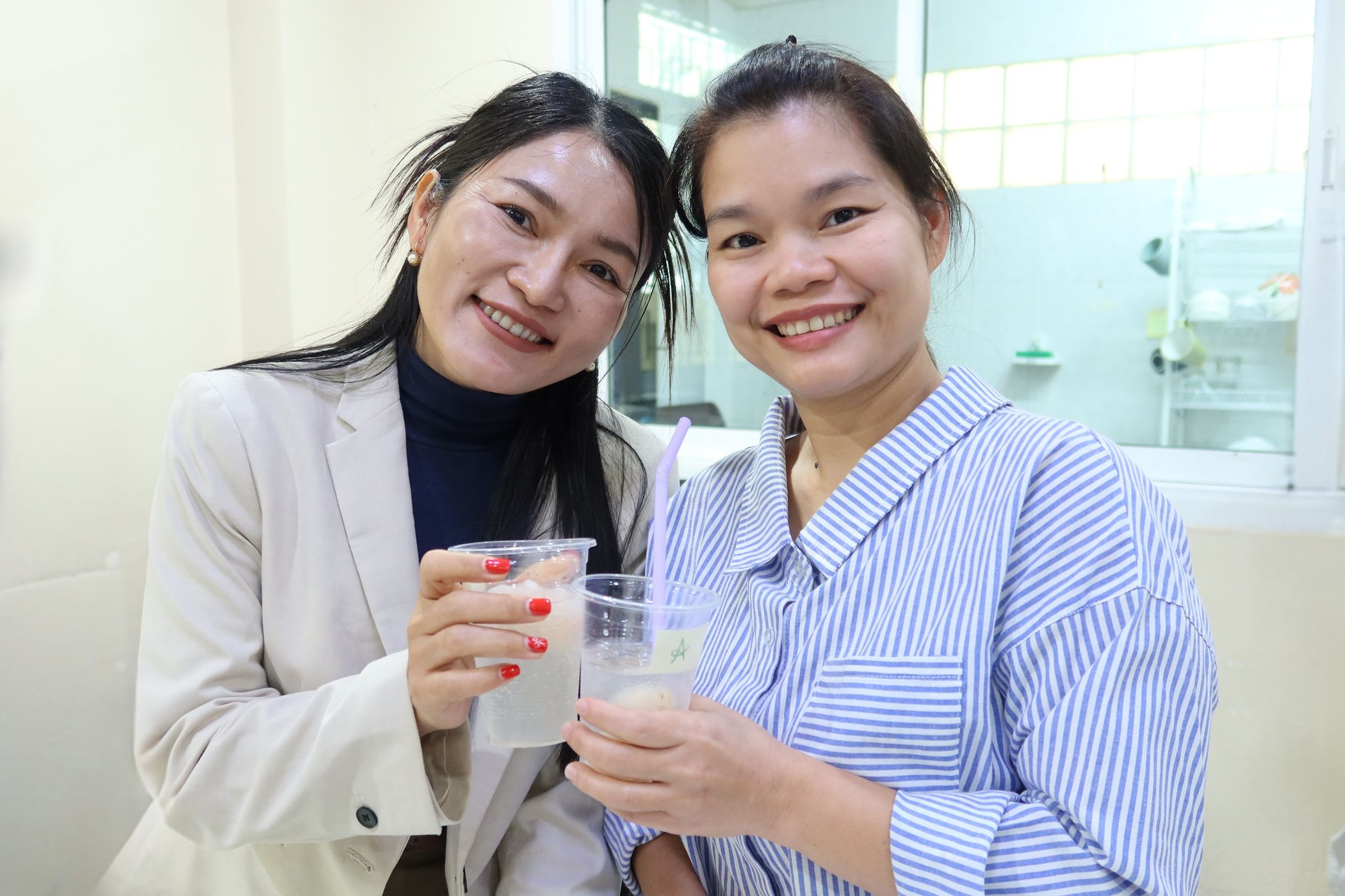 Phe and Eh are smiling while holding a mocktail for the camera at the Better Me Connect Workshop.